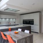 Hacker handless gloss graphite base and island units mixed with light grey gloss wall and tall units featuring stainless steel slimline handles.