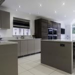 Light bright and earthy warm tones throughout this Hacker handless kitchen help create a welcoming atmosphere with the cool modern look of the appliances and fixtures.
