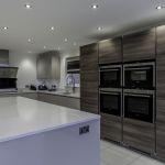 Light bright and earthy warm tones throughout this Hacker handless kitchen help create a welcoming atmosphere with the cool modern look of the appliances and fixtures.