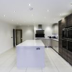 Light bright and earthy warm tones throughout this Hacker handless kitchen help create a welcoming atmosphere with the cool modern look of the appliances and fixtures.